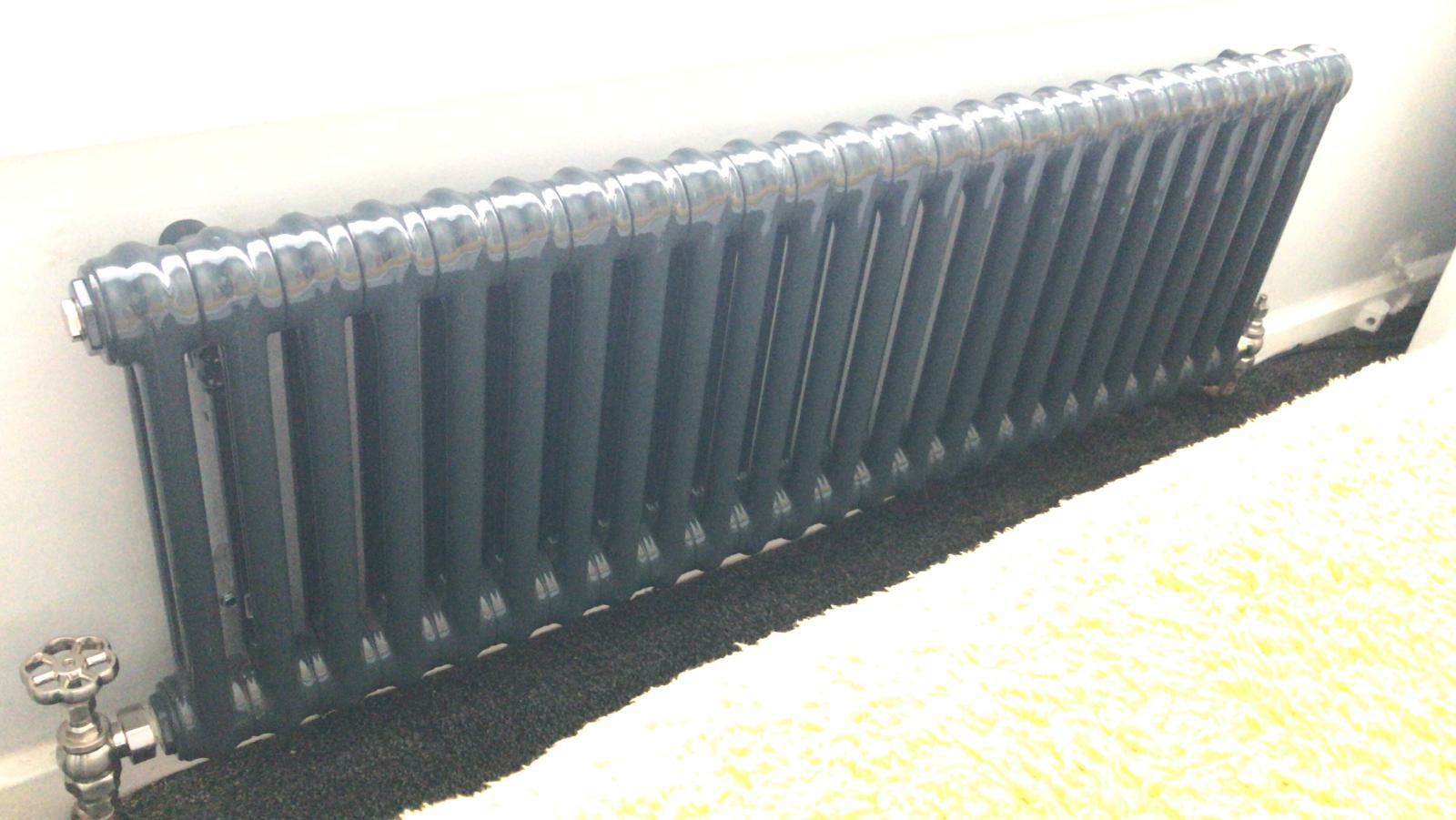 An anthracite column radiator fitted low on a wall