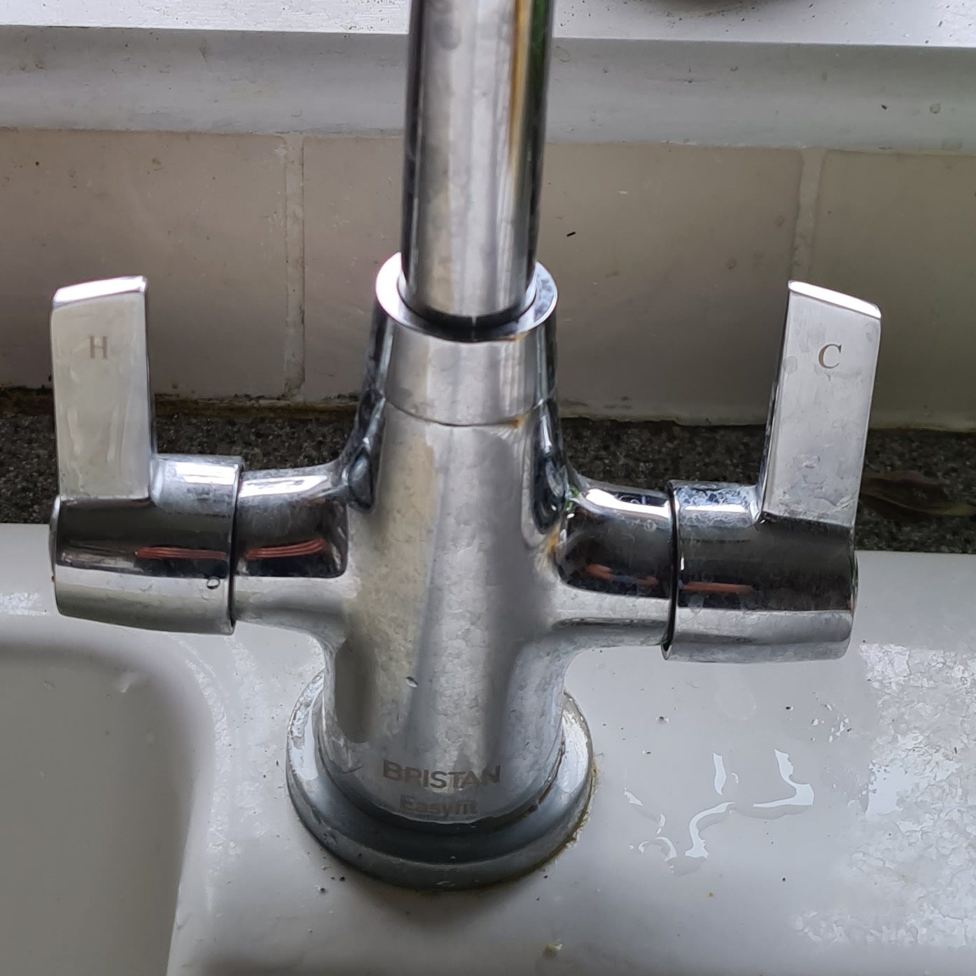 Close-up of a chrome twin-lever mixer tap on a sink